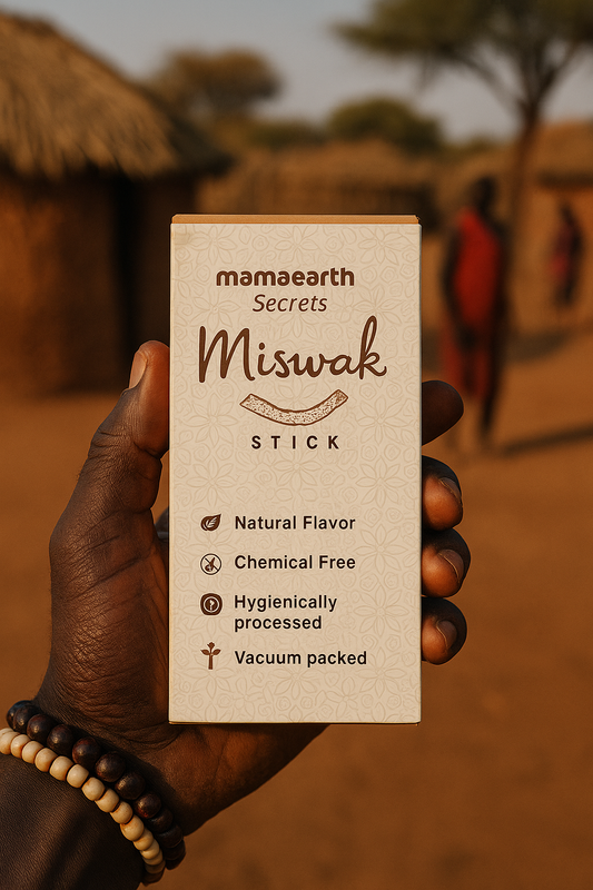 Hand holding a Mamaearth Miswak Stick packaging with a rustic background